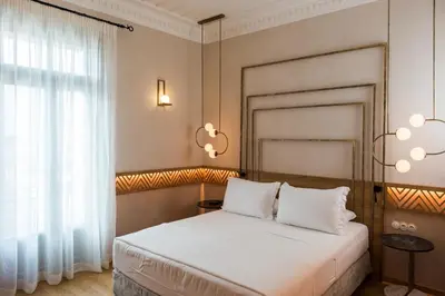 a bedroom with a bed and a window and chandeliers at Scala de Faro in Chania Town