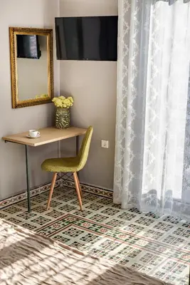 a room with a table and a chair and a mirror at Mosaic in Chania Town