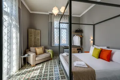 a hotel room with a bed and a chair at Mosaic in Chania Town