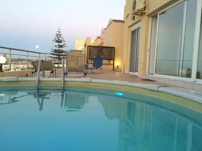a swimming pool in front of a house at Blue Villas in Agia Marina Nea Kydonias