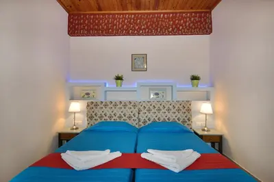a bedroom with a blue bed with two night stands at Mythos- Platanias- Hotel -Apts in Plataniás