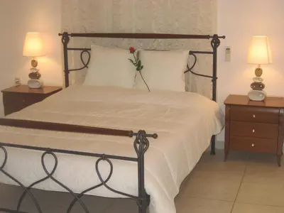 a bedroom with a bed with a flower on it at Mythos- Platanias- Hotel -Apts in Plataniás