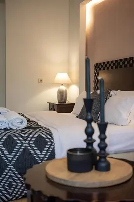 a bedroom with two beds and a table with two candles at Vranas Ambiance Hotel in Chania Town