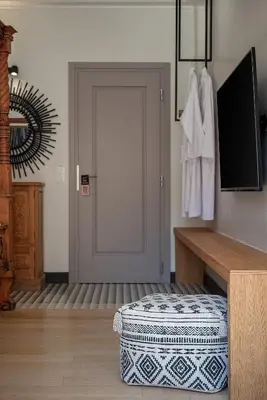 a room with a door and a ottoman in front of it at Vranas Ambiance Hotel in Chania Town