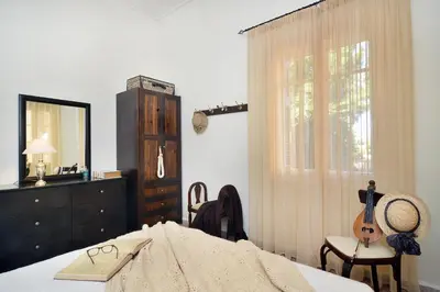 a bedroom with a bed and a dresser and a guitar at Haralabos Central Apartment in Chania Town