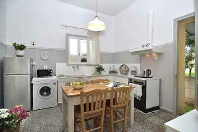 a kitchen with a table and a stove and refrigerator at Haralabos Central Apartment in Chania Town