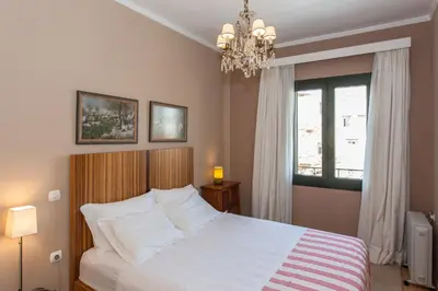 a bedroom with a large white bed with a chandelier at Spolia Art Maison in Chania Town