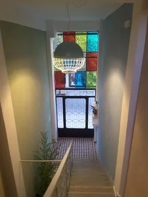a hallway with a staircase with a stained glass window at TheJoy City Suites in Chania Town
