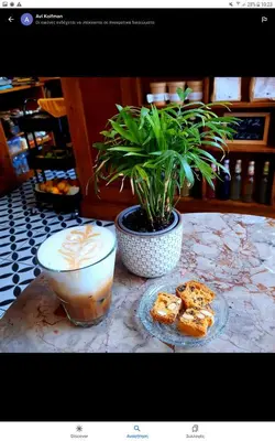 a table with a cup of coffee and a potted plant at TheJoy City Suites in Chania Town