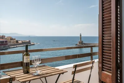 a table with a bottle of wine and two glasses at Amphitrite Hotel in Chania Town