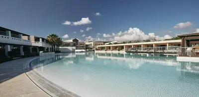 a large swimming pool with blue water in a building at Giannoulis – Cavo Spada Luxury Sports & Leisure Resort & Spa in Kolymvari