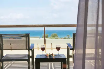 two glasses of wine on a table with a view of the beach at Giannoulis – Cavo Spada Luxury Sports & Leisure Resort & Spa in Kolymvari