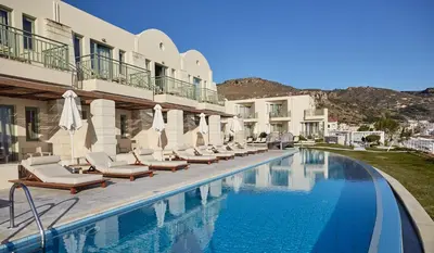a swimming pool with chairs and umbrellas next to a building at Giannoulis - Grand Bay Beach Resort (Exclusive Adults Only) in Kolymvari