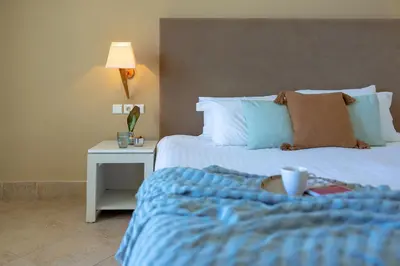 a bedroom with a bed and a table with a night stand at Giannoulis - Grand Bay Beach Resort (Exclusive Adults Only) in Kolymvari