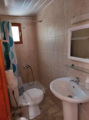 a small bathroom with a sink and a toilet at Potoula Apts in Kato Daratso