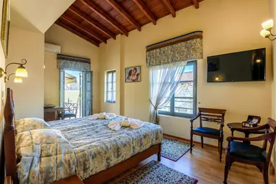 a bedroom with a bed and a flat screen tv at Belmondo Hotel in Chania Town