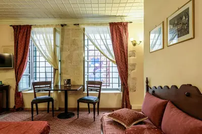 a living room with a table and chairs and a couch at Belmondo Hotel in Chania Town