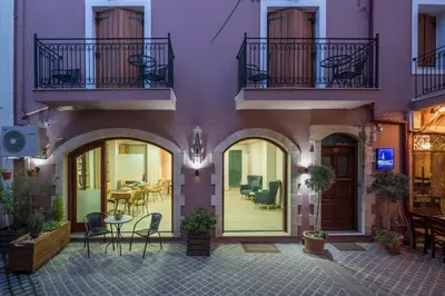 a purple building with chairs and a table on a patio at Minaret Suites and Apartments in Chania Town