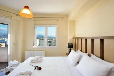 a bedroom with a large white bed with a window at Elia Selinou in Chania Town