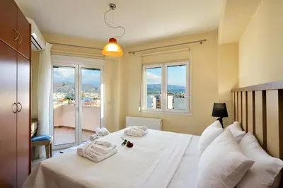 a bedroom with a large white bed with a window at Elia Selinou in Chania Town