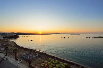 a view of a beach with a sunset in the ocean at Elia Penthouse in Chania Town