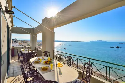 a balcony with tables and chairs and a view of the ocean at Elia Penthouse in Chania Town