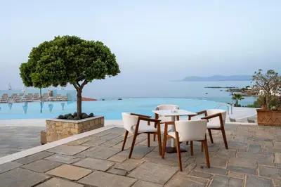 a table and chairs with a view of the water at Leptos Panorama Hotel in Kalamaki Chanion