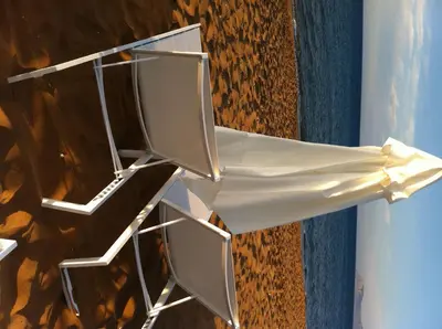 a white chair sitting next to a wall at Phaedra Hotel in Stalos