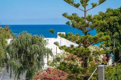 a view of a white building and the ocean at Villa AERAS in Kato Daratso