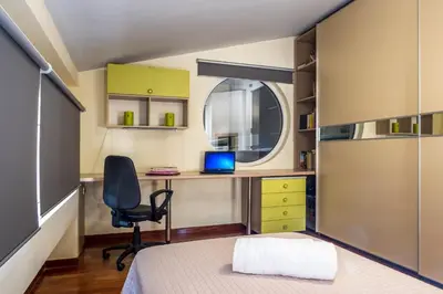 a bedroom with a bed and a desk with a laptop at Villa AERAS in Kato Daratso