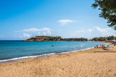 a beach with a group of people swimming in the ocean at Villa AERAS in Kato Daratso