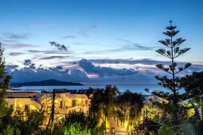 a view of a building and the ocean at dusk at Villa AERAS in Kato Daratso