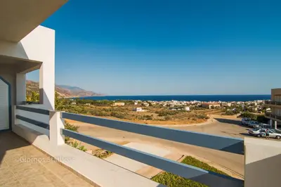 a view of the ocean from the balcony of a house at Roula Apartments in Palaiochóra
