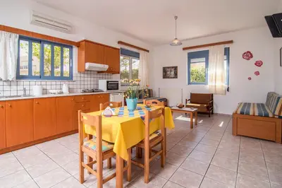a kitchen and dining room with a table and chairs at Roula Apartments in Palaiochóra