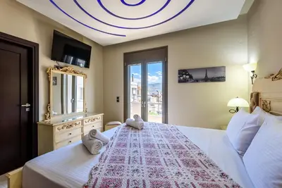 a bedroom with a large bed with a large window at Evgenias Luxury Apartment with Rooftop Pool in Chania Town