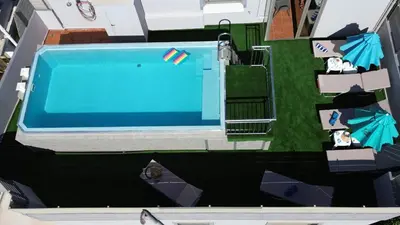 an overhead view of a swimming pool with chairs and umbrellas at Evgenias Luxury Apartment with Rooftop Pool in Chania Town