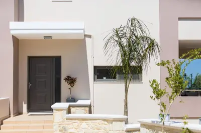 a white house with a black door and a plant at Peris Villa in Kato Daratso