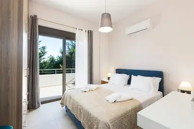 a bedroom with two beds and a balcony at Peris Villa in Kato Daratso