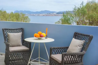 two chairs and a table with a bowl of fruit on a balcony at Minoos Hotel in Chania Town