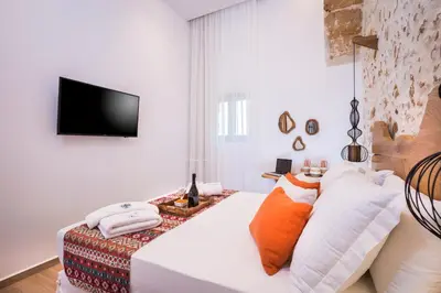 a bedroom with a bed with pillows and a television at Madonna del Mare in Chania Town
