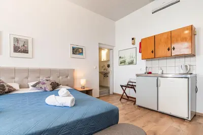 a bedroom with a blue bed and a kitchen at Villa Venezia in Chania Town