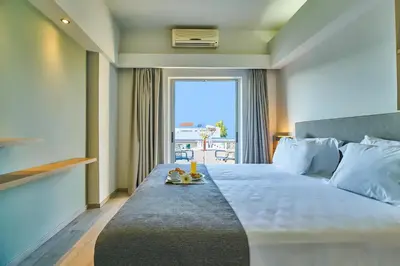 a hotel room with a large bed with a window at Bella Pais in Maleme