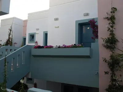 a balcony with flowers on a building at Hotel Kleopatra in Stalos