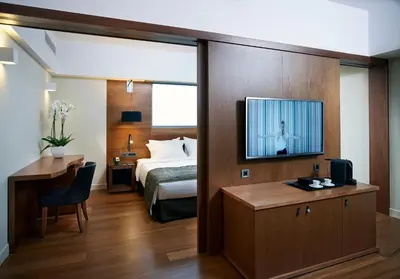a hotel room with a bed and a television on a wall at Samaria Hotel in Chania Town