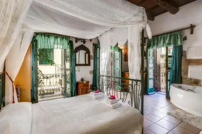 a bedroom with a large bed and a tub at Ifigenia Rooms in Chania Town