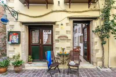 a patio with chairs and a table in front of a building at Ifigenia Rooms in Chania Town