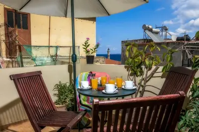 a table with cups and drinks on a balcony at Ifigenia Rooms in Chania Town