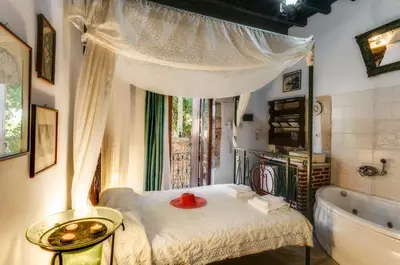 a bathroom with a tub and a bed and a sink at Ifigenia Rooms in Chania Town