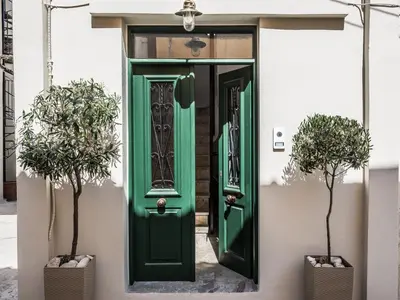 a green door on a building with two plants at Casa Giulietta Modern Luxury Maisonette in Chania Town