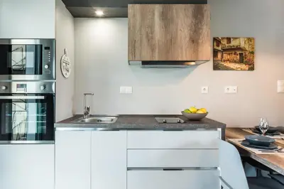 a kitchen with white cabinets and a wooden table at Casa Giulietta Modern Luxury Maisonette in Chania Town